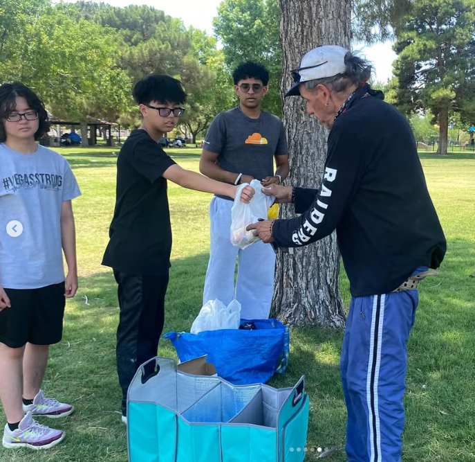 Volunteers distributing supplies to homeless individuals in park